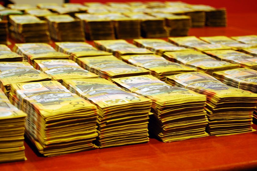 Bundles of $50 bank notes in piles.