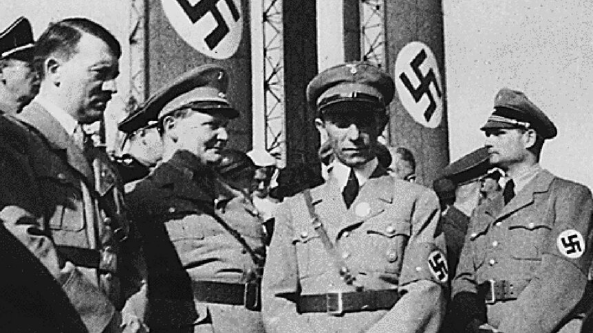Hiitler stands with Nazi commanders