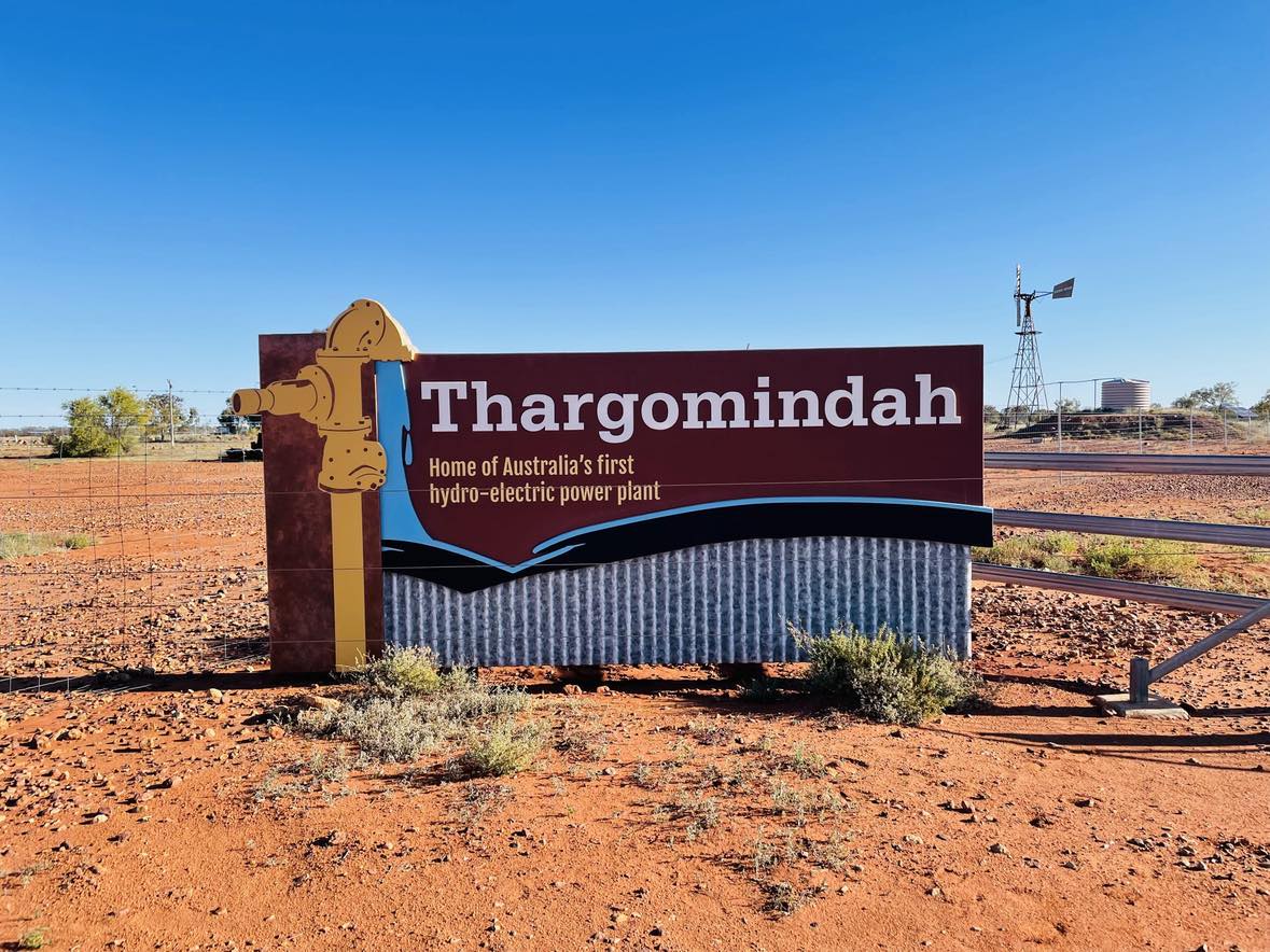 El cartel de la ciudad de Thargomindah al lado de una carretera polvorienta. 