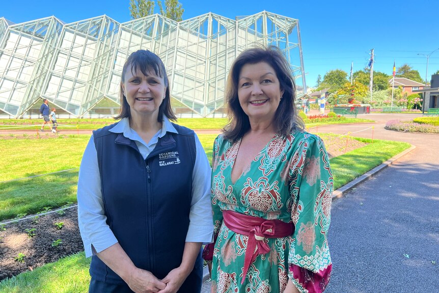 Donna Thompson and Cr Samantha McIntosh standing side by side with Botanical Gardens nursery building behind them.
