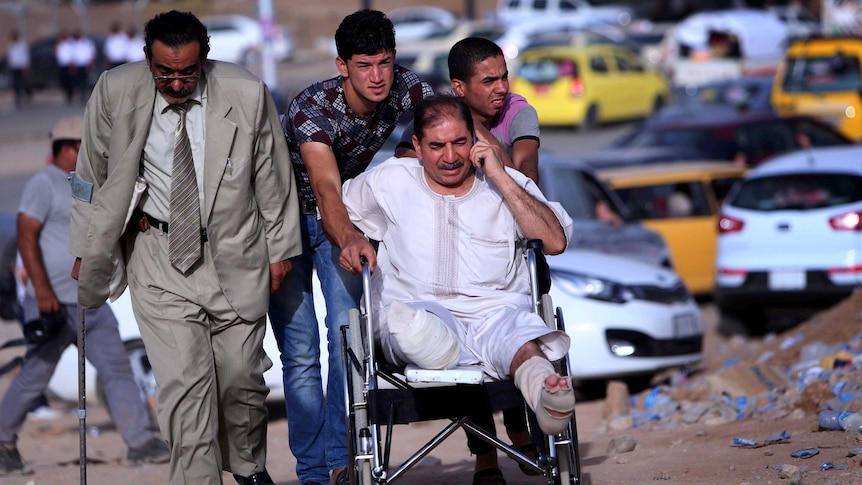 An Iraqi man in a wheelchair fleeing violence