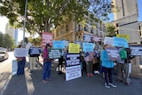 Euthanasia protesters hold signs outside parliament