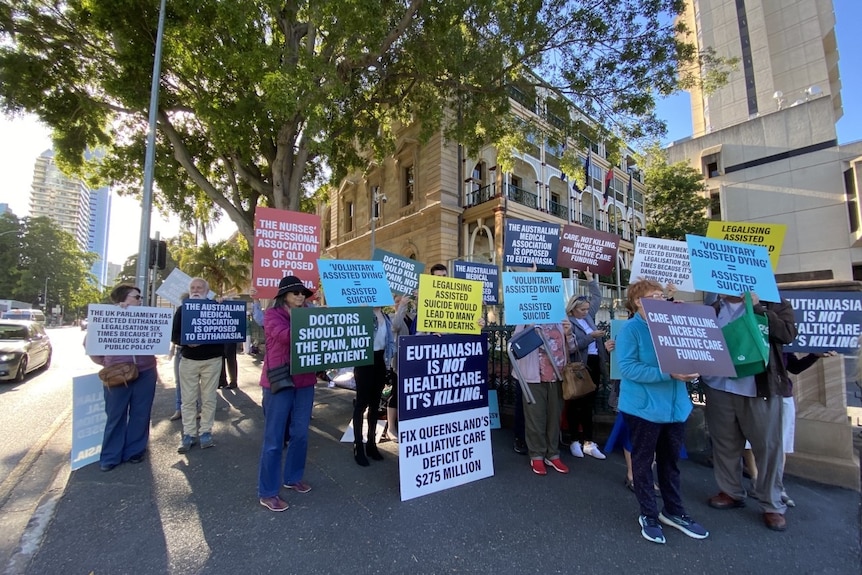 Euthanasia protesters hold signs outside parliament