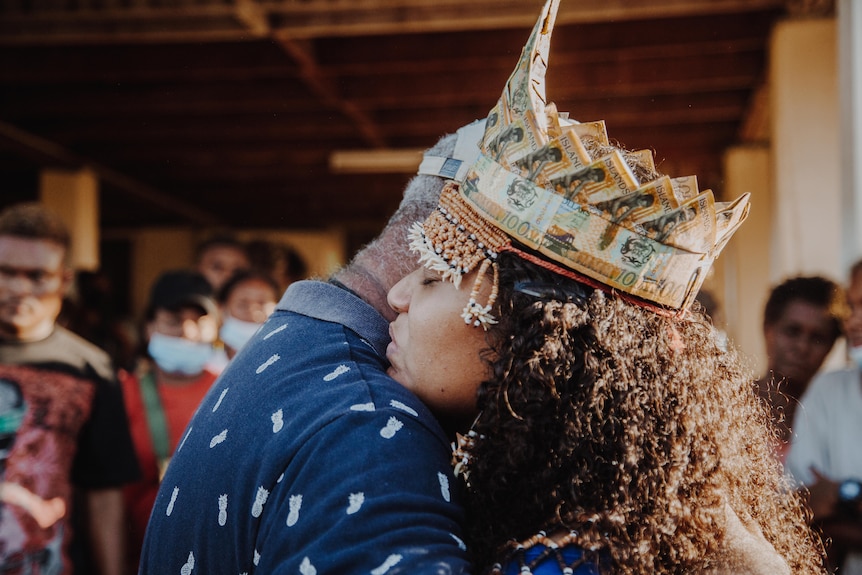 A young woman hugs her father.