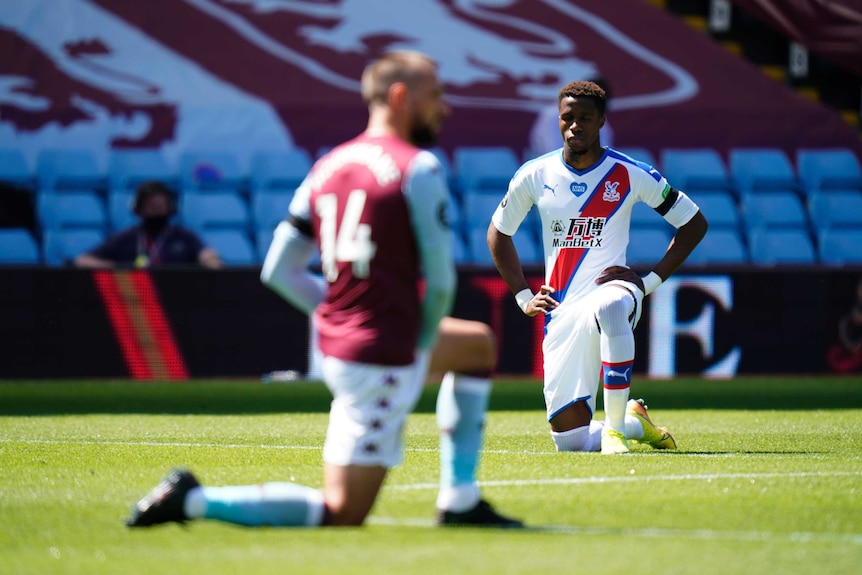 A Premier League player goes on one knee in a pre-match ceremony.