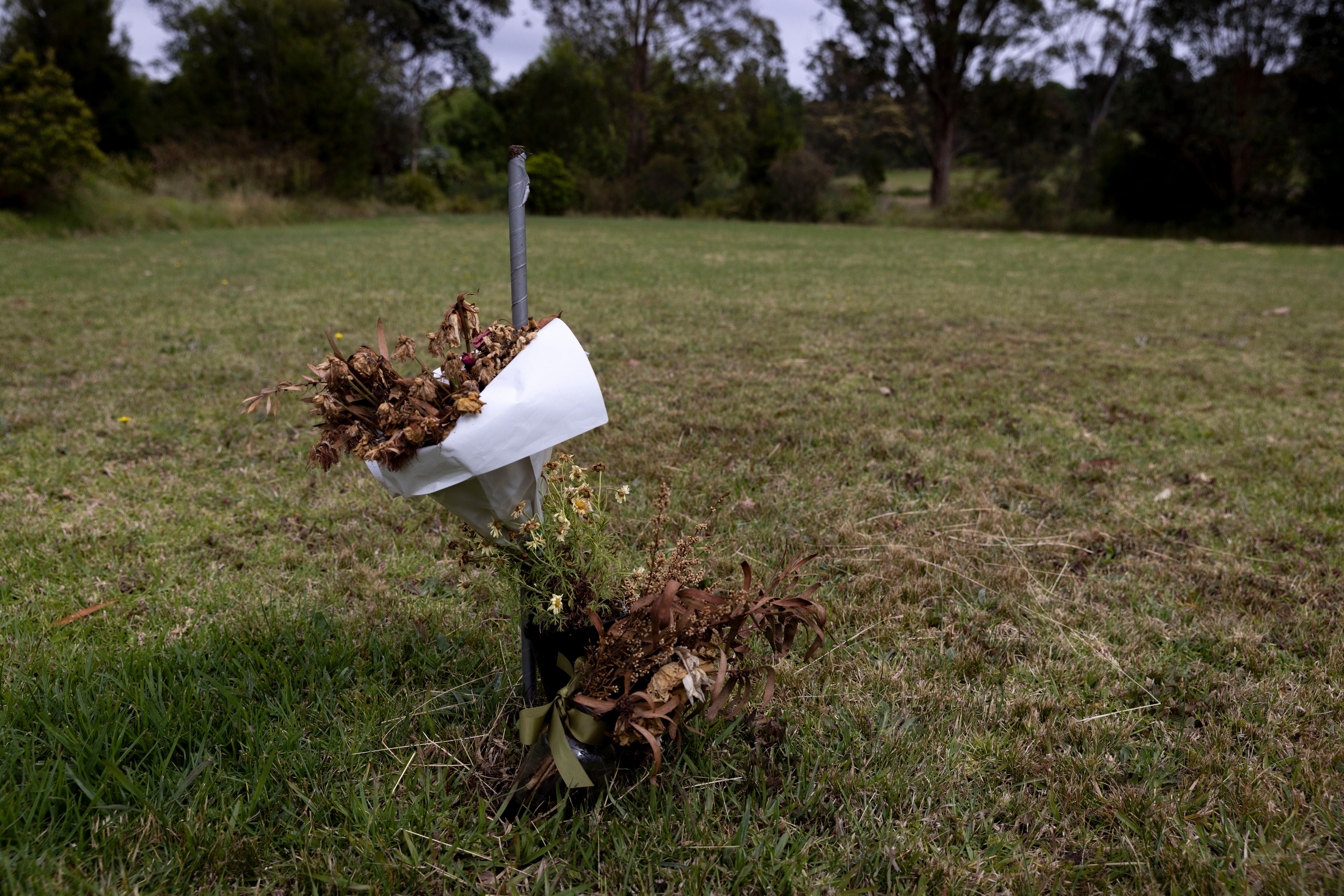 Flores mortas amarradas a um poste.