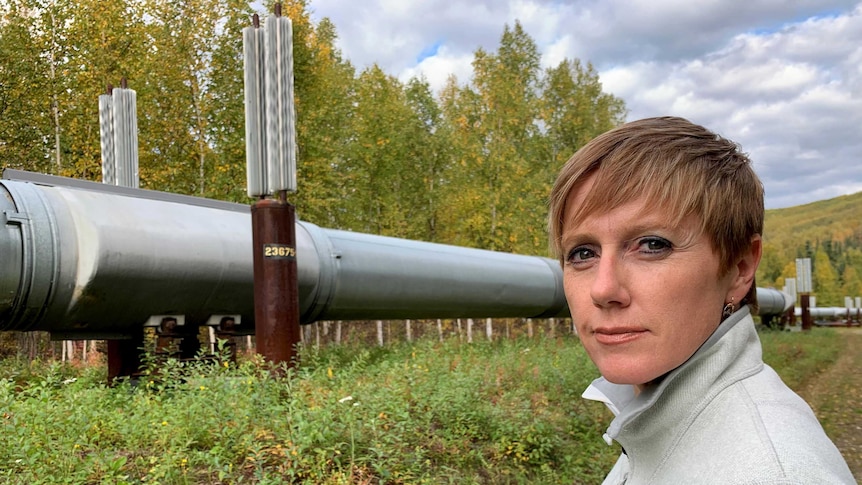 Reporter Zoe Daniel stands in front of a silver pipe.