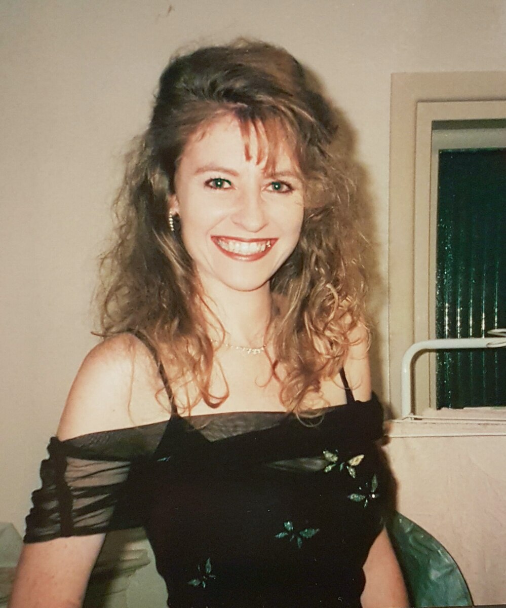 A woman smiling and wearing a dress