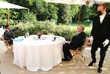 Morrison and Macron at a table in the garden.