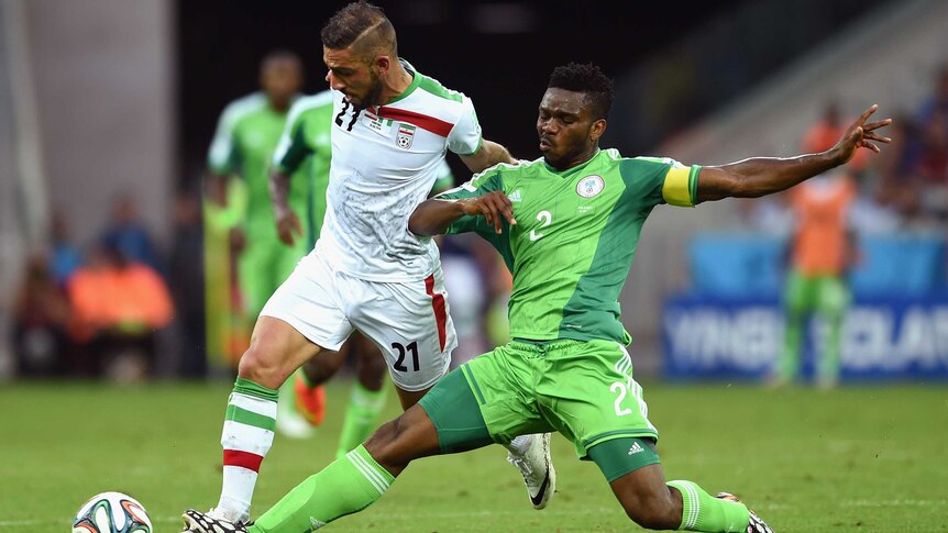 Joseph Yobo of Nigeria tackles Ashkan Dejagah of Iran