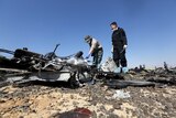 Military investigators from Russia check debris from a Russian airliner at its crash site.