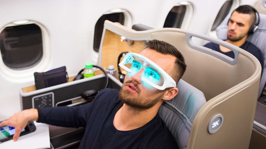 Bailey Wright reclines on a flight wearing ReTimers glasses.