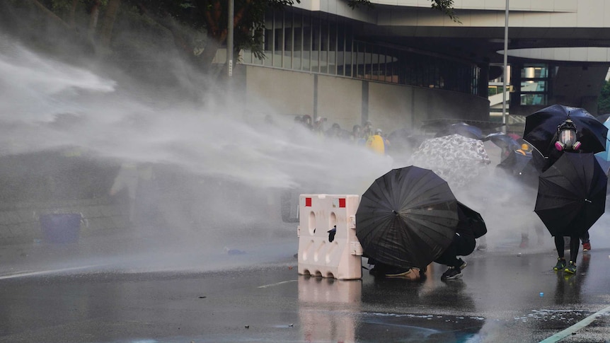 在香港政府总部附近的示威活动中，警方向抗议者喷射高压水枪。