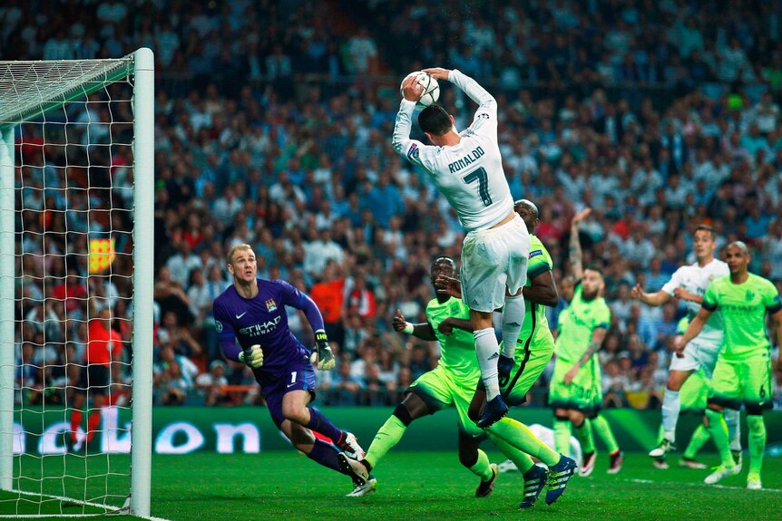 Real Madrid's Cristiano Ronaldo catches the ball before throwing it into the Manchester City net.