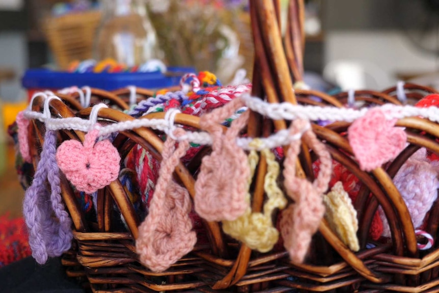 A basketful of crocheted, colourful hearts.