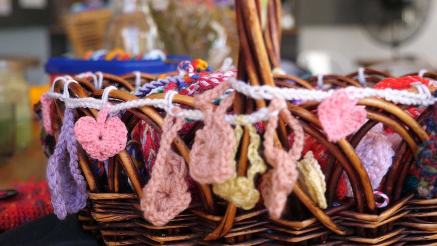 A basketful of crocheted, colourful hearts.