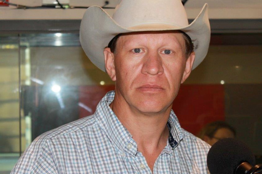 Wyoming farmer John Fenton looks at the camera wearing a cowboy hat.