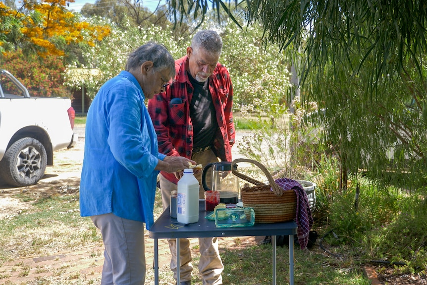 Rochelle Patten and Leon Atkinson making a cup of tea and scone in a garden in Barmah, Victoria, November 2023.