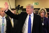 Donald Trump walks among staff and waves as he arrives at the World Economic Forum in Davos.