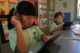 Mount Ousley Public School kindergarten pupils using an iPad in class.