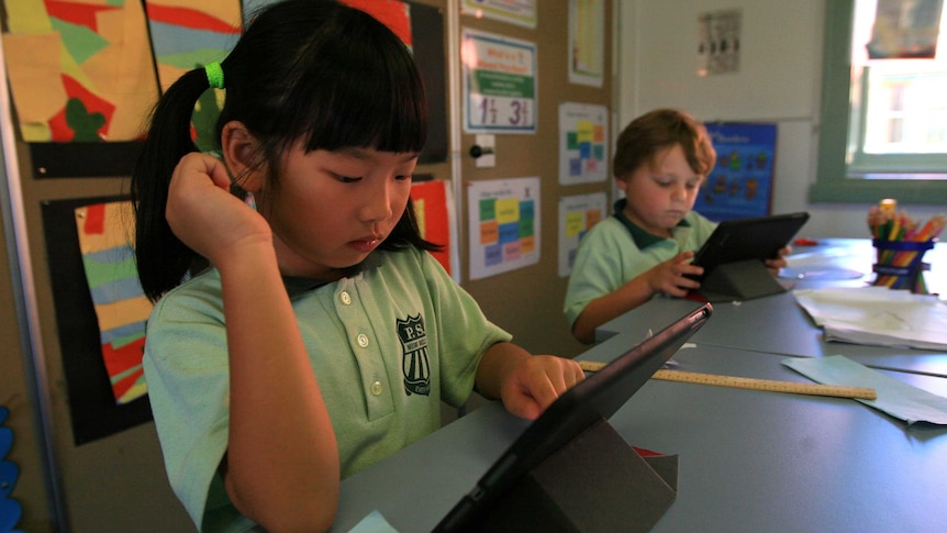 Mount Ousley Public School kindergarten pupils using an iPad in class.