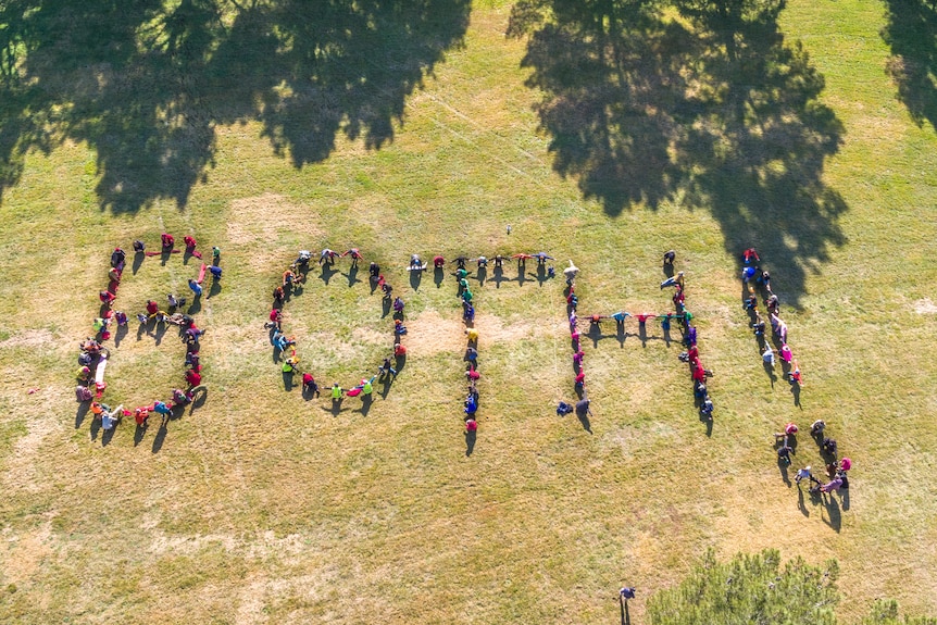Aerial photo of people standing to form the word 'both' 