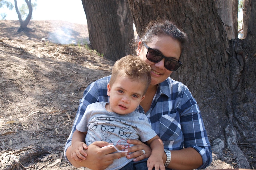 Indigenous mother and child at Aboriginal mission open day.