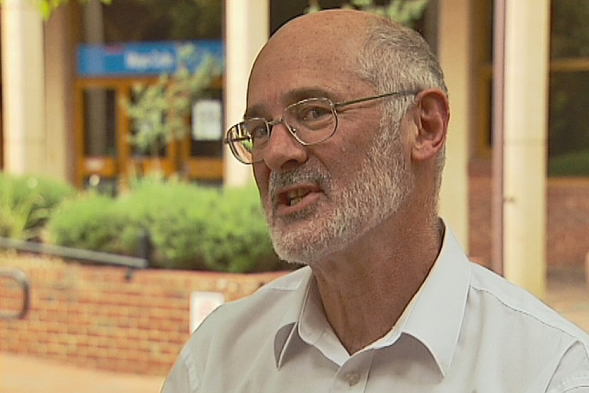 A bald man with a beard wearing a white shirt