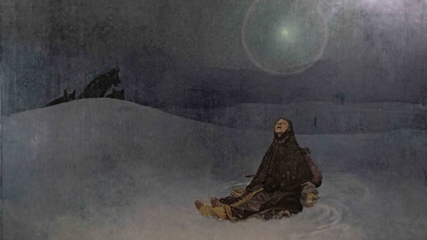 Woman sitting in the snow looking into the misty sky