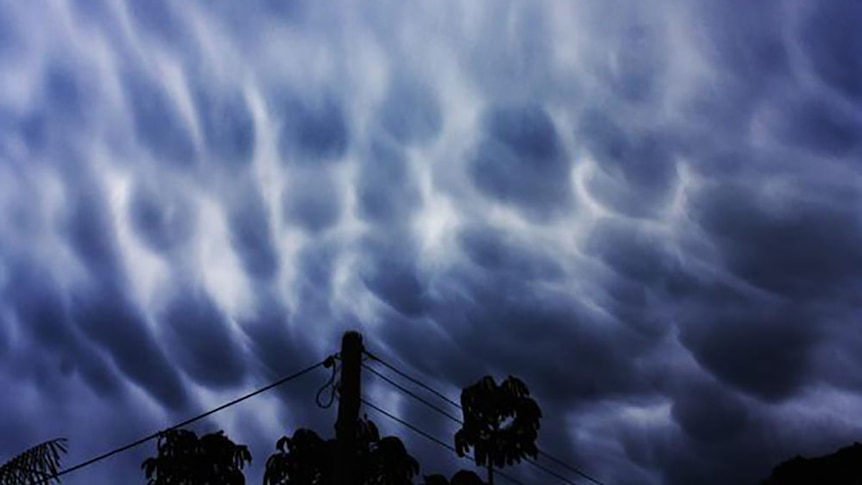 A luminous storm cloud over Brisbane looks both beautiful and threatening