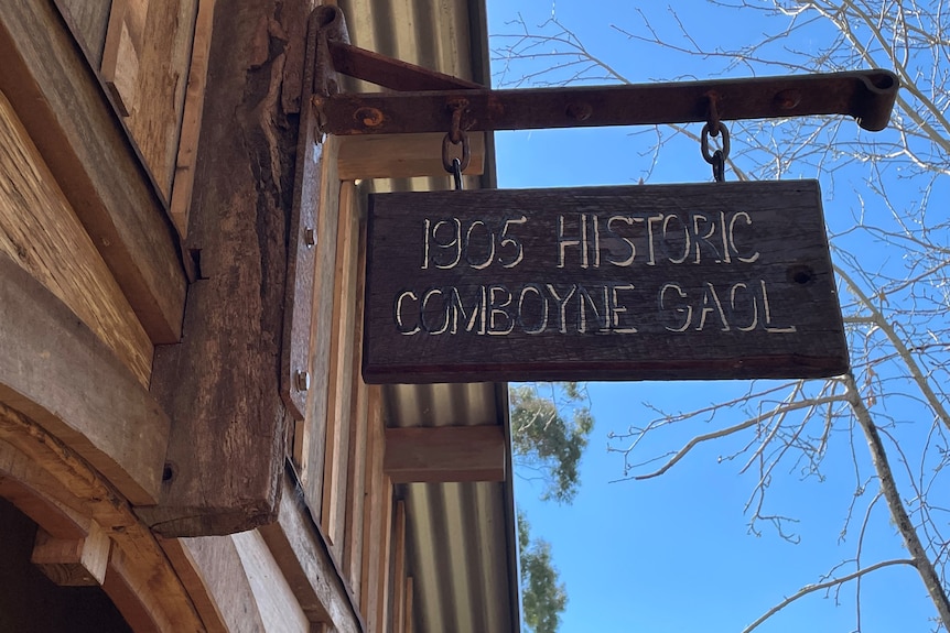 A timber sign outside a timber building, saying '1905 Comboyne Gaol'.