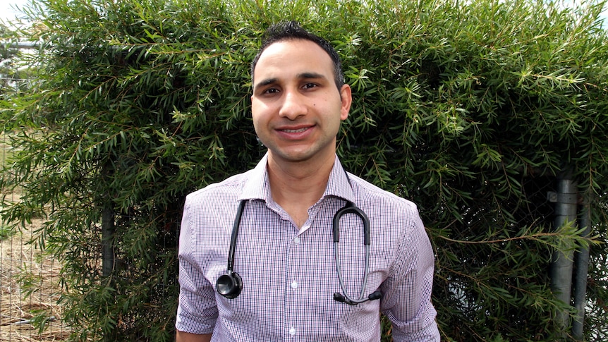 Ram Khanal smiles while wearing a stethoscope.