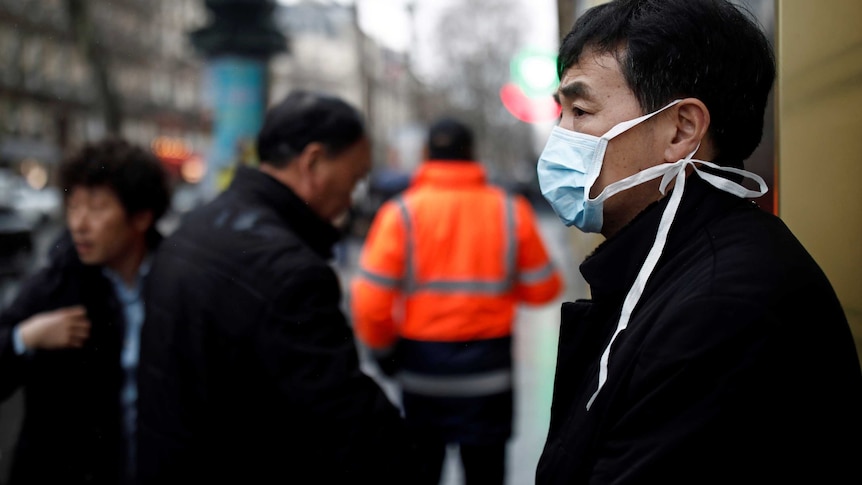 A tourist wears a protective mask in front of the Galeries Lafayette department store.