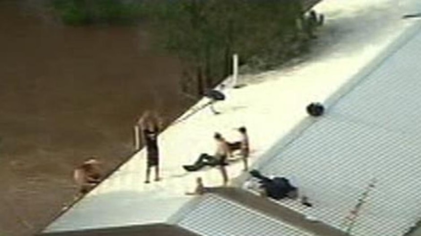 Lockyer Valley residents sit on a roof as flash floods sweep through the valley on January 10, 2011.