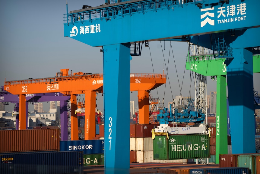 A crane lifts a shipping container at an automated container port in Tianjin, China.