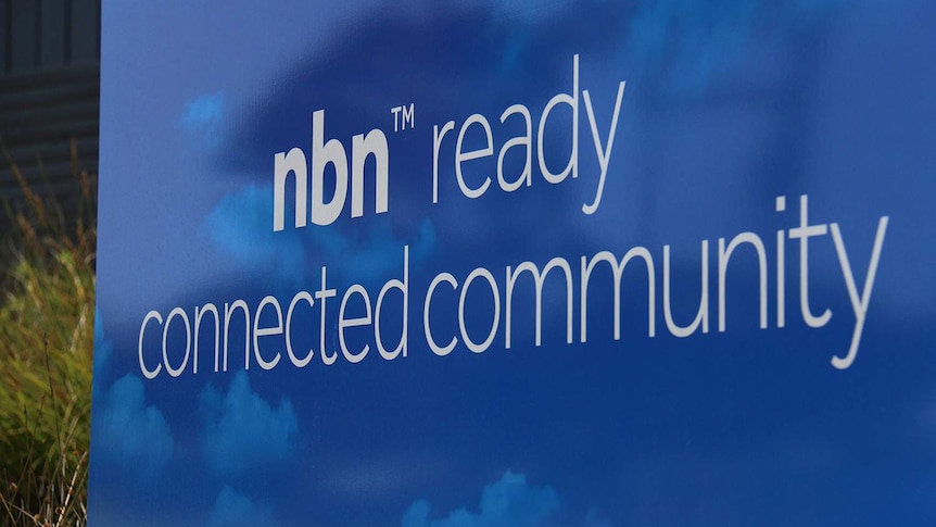 Close-up of blue sign in street reading 'NBN ready connected community' at a new housing estate.