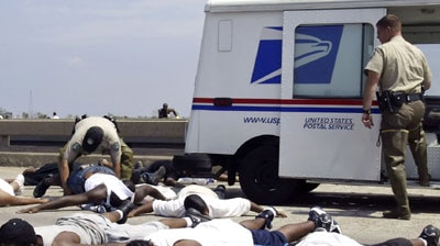 Texas game wardens watch over people who were caught using a mail truck to try to escape New Orleans.