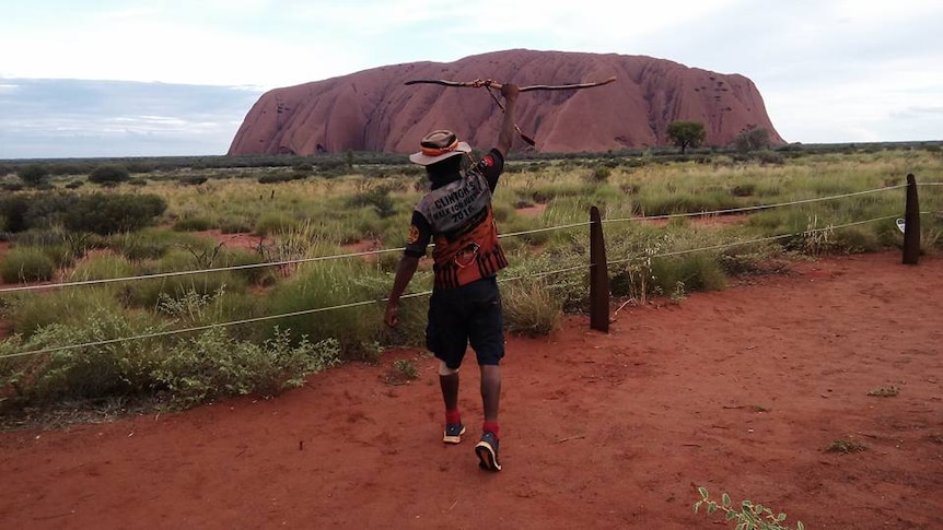 Clinton stands jubilant in front of Uluru