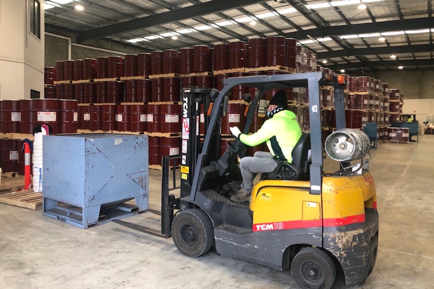 A warehouse with hundreds of stacked drums containing mouse poison