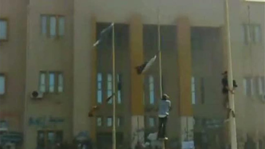 Protesters climb flag poles in front of Libya's internal security headquarters