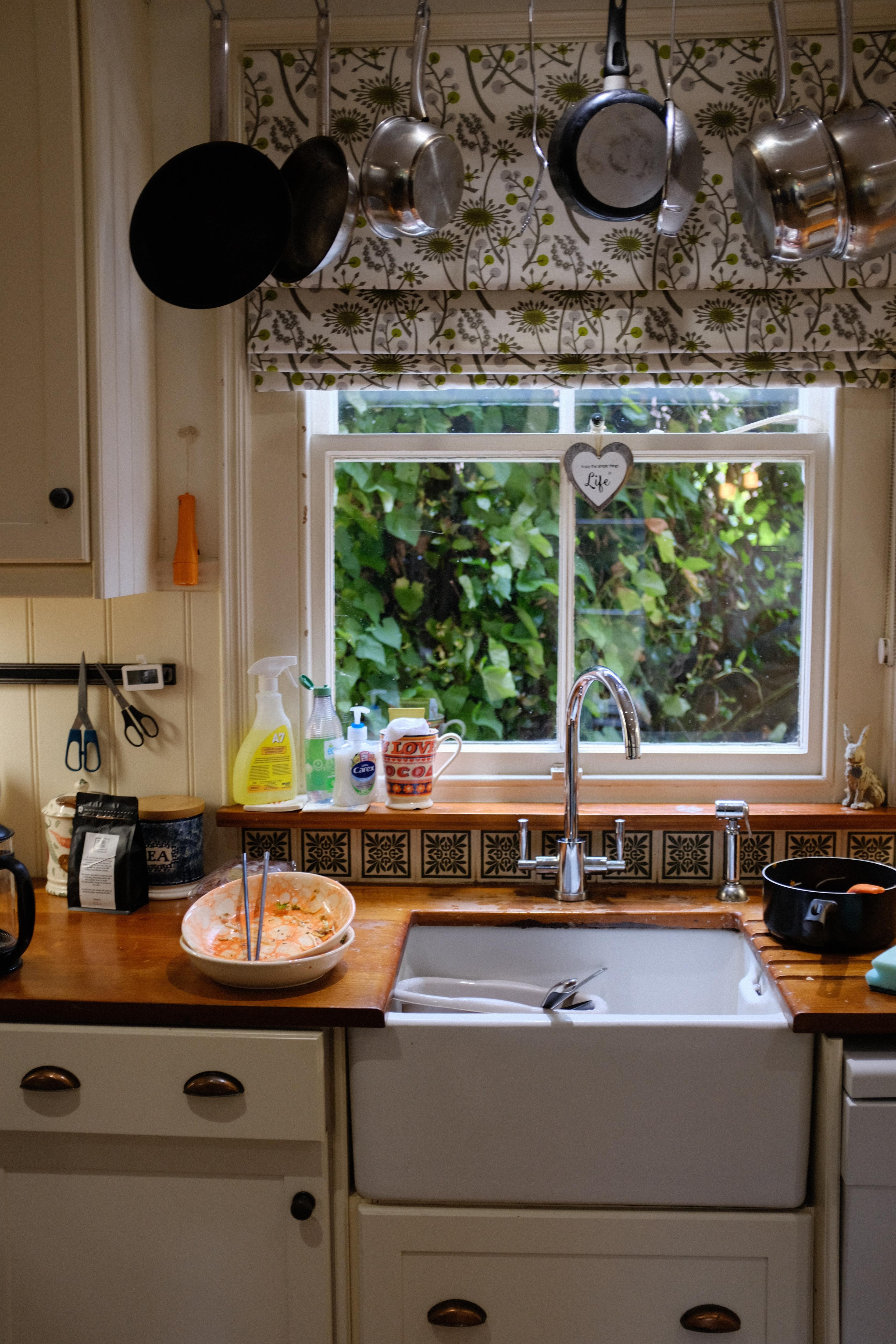 A kitchen bench with a dirty plate next to the sink.