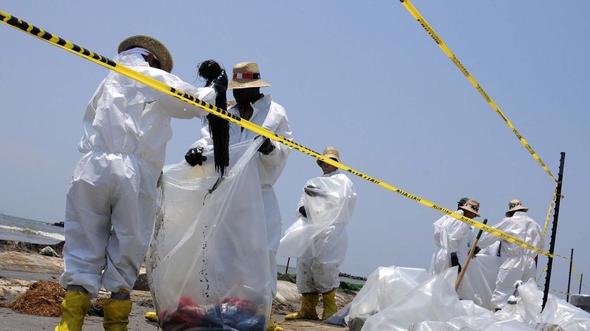 Health, Safety and Environment workers place part of an oil snare boom into bags