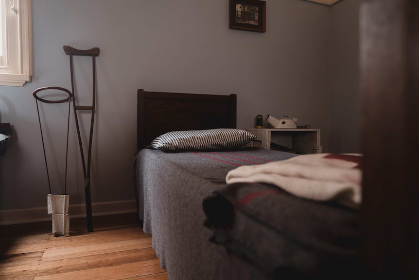 A picture of an old hospital room with a wooden bed and old medical instruments.