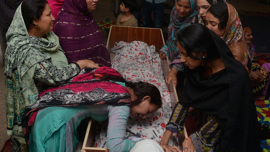 Pakistani relatives mourn over the body of a victim during a funeral following a suicide bombing in Lahore.