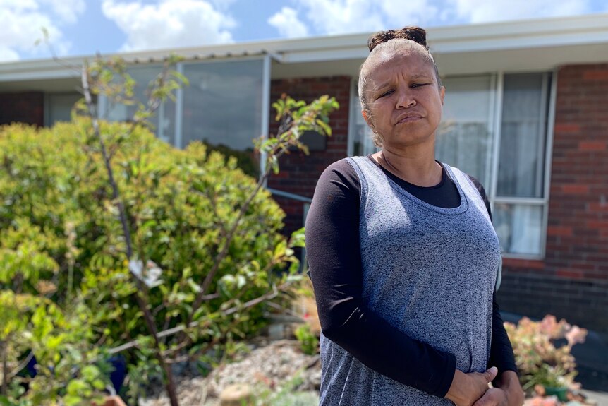 a woman stands outside a house