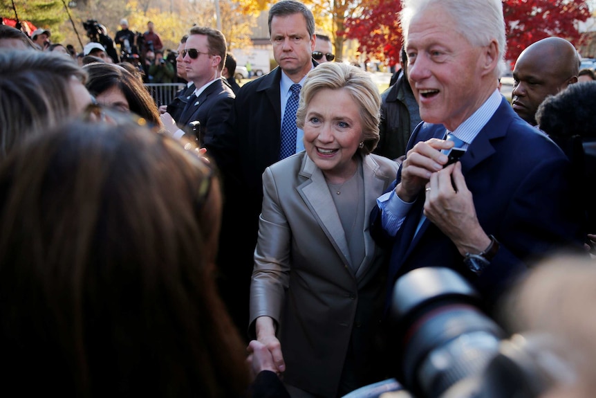 Hillary Clinton and Bill Clinton greet supporters after casting their ballots