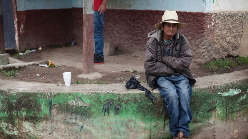 A neighbour sits outside the house of Claudia Gomez Gonzalez