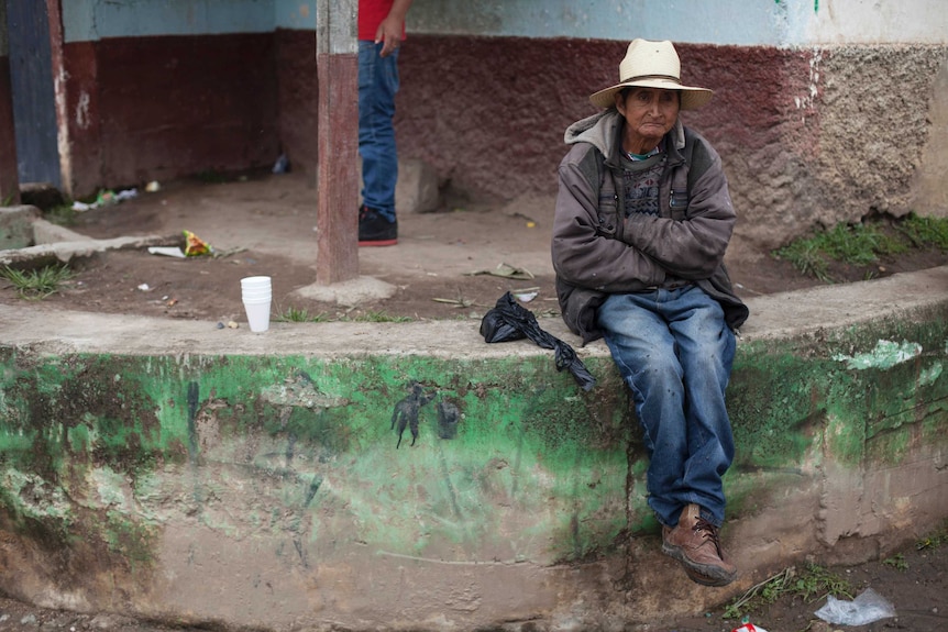 A neighbour sits outside the house of Claudia Gomez Gonzalez