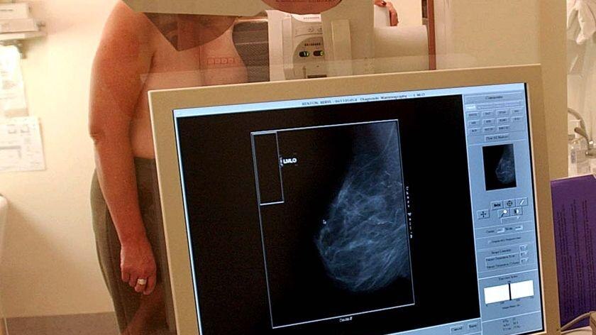 A woman undergoes a mammogram