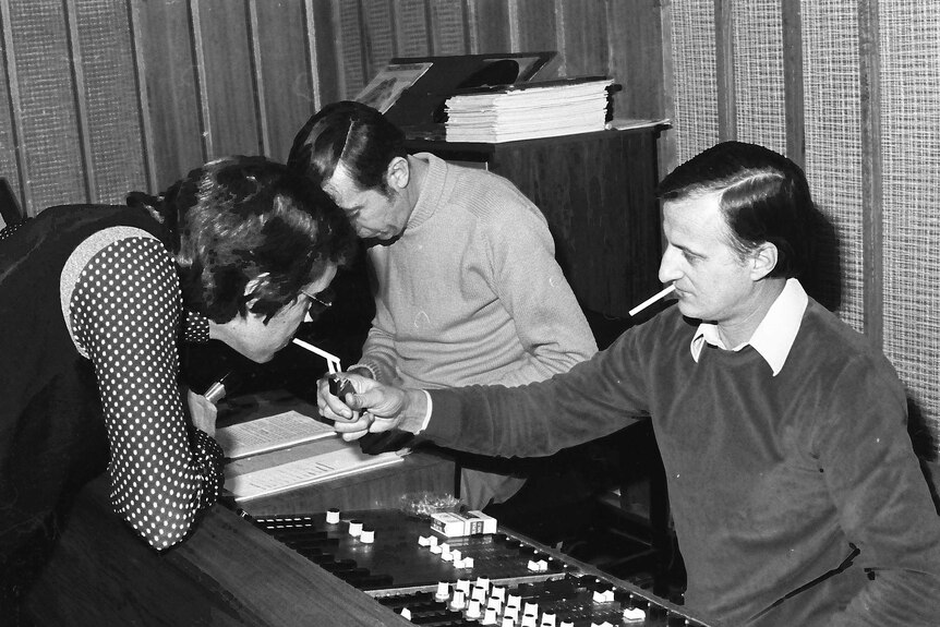 A man lights a cigarette in the ABC AM studios in 1977.